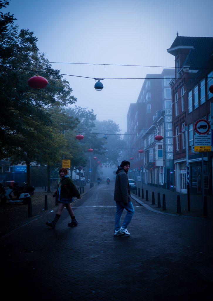 MIsty morning, two people crossing the street in different direction